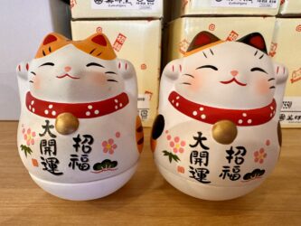 Japan, Kyoto - A maneki-neko (beckoning cat) at Nishiki Market
